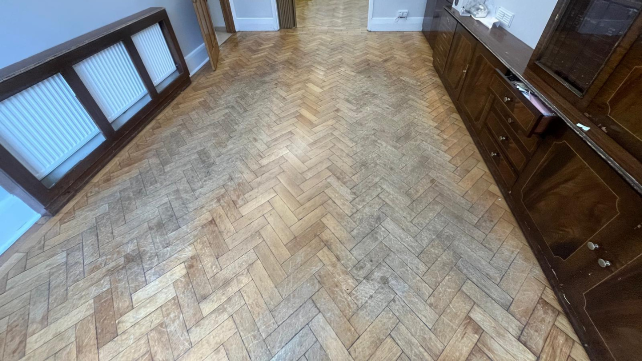 Faded oak herringbone parquet floor in a Rainham home awaiting Restoring Classic Herringbone treatment.
