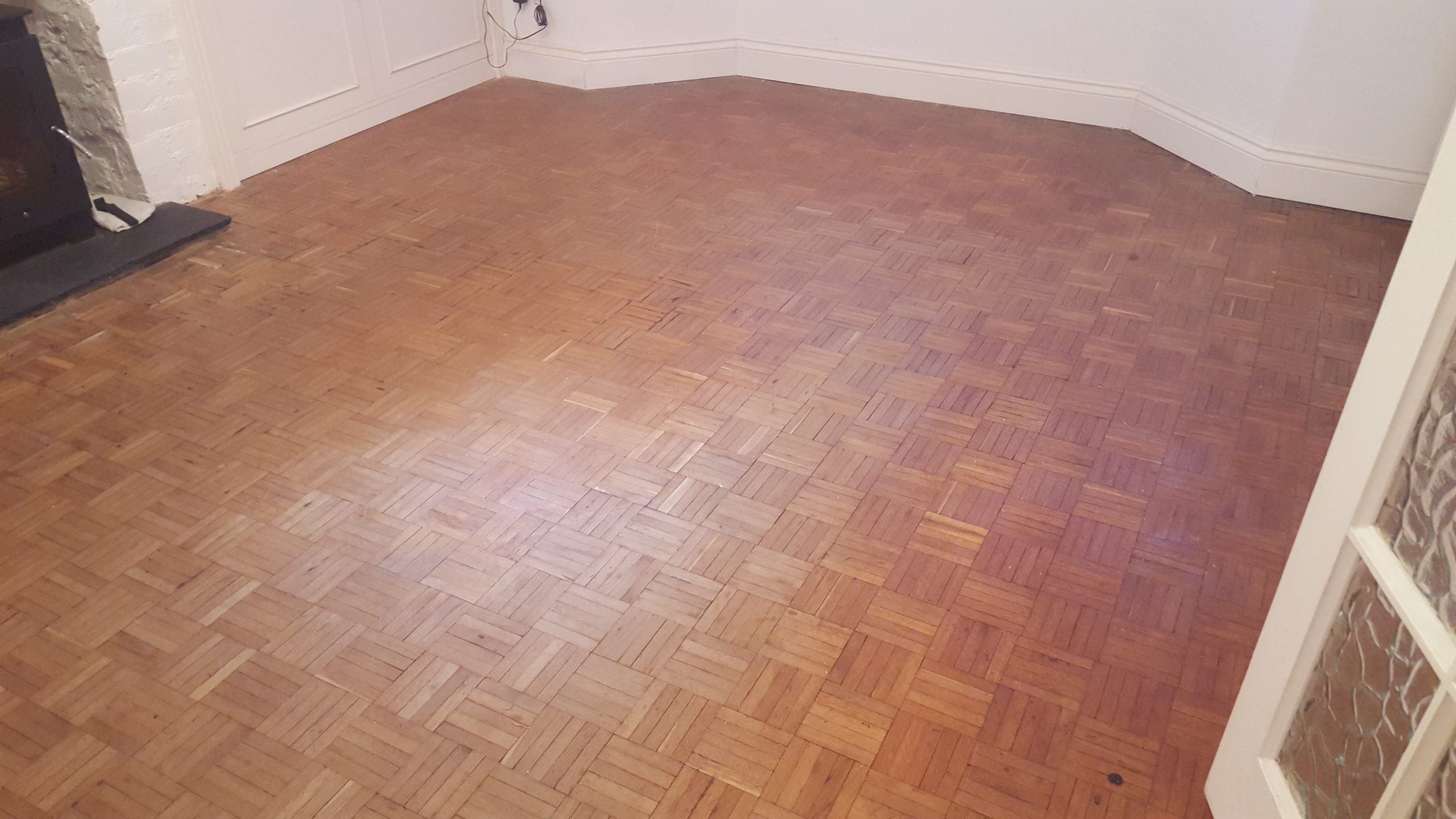 Living room in Rainham with a worn oak finger-block parquet hardwood floor before Wood Floor Sanding in Rainham.