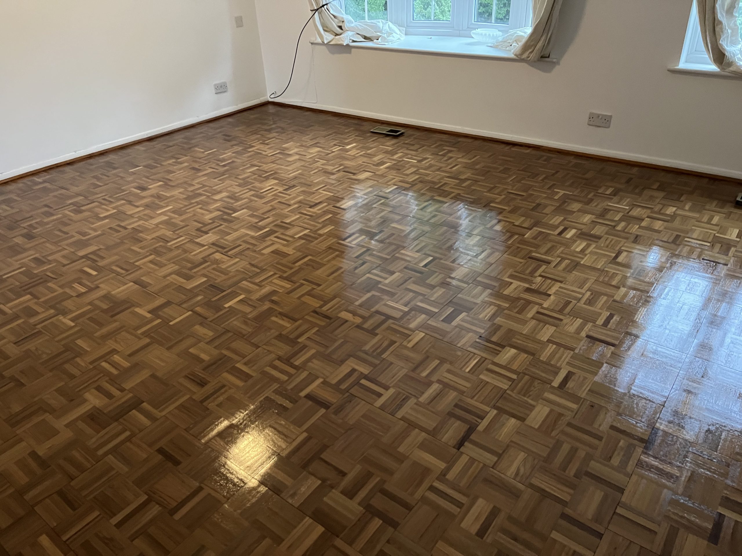Wood Floor Sanding in Rainham on an oak finger-block parquet hardwood floor, fully restored with a smooth, glossy finish in a bright living room.