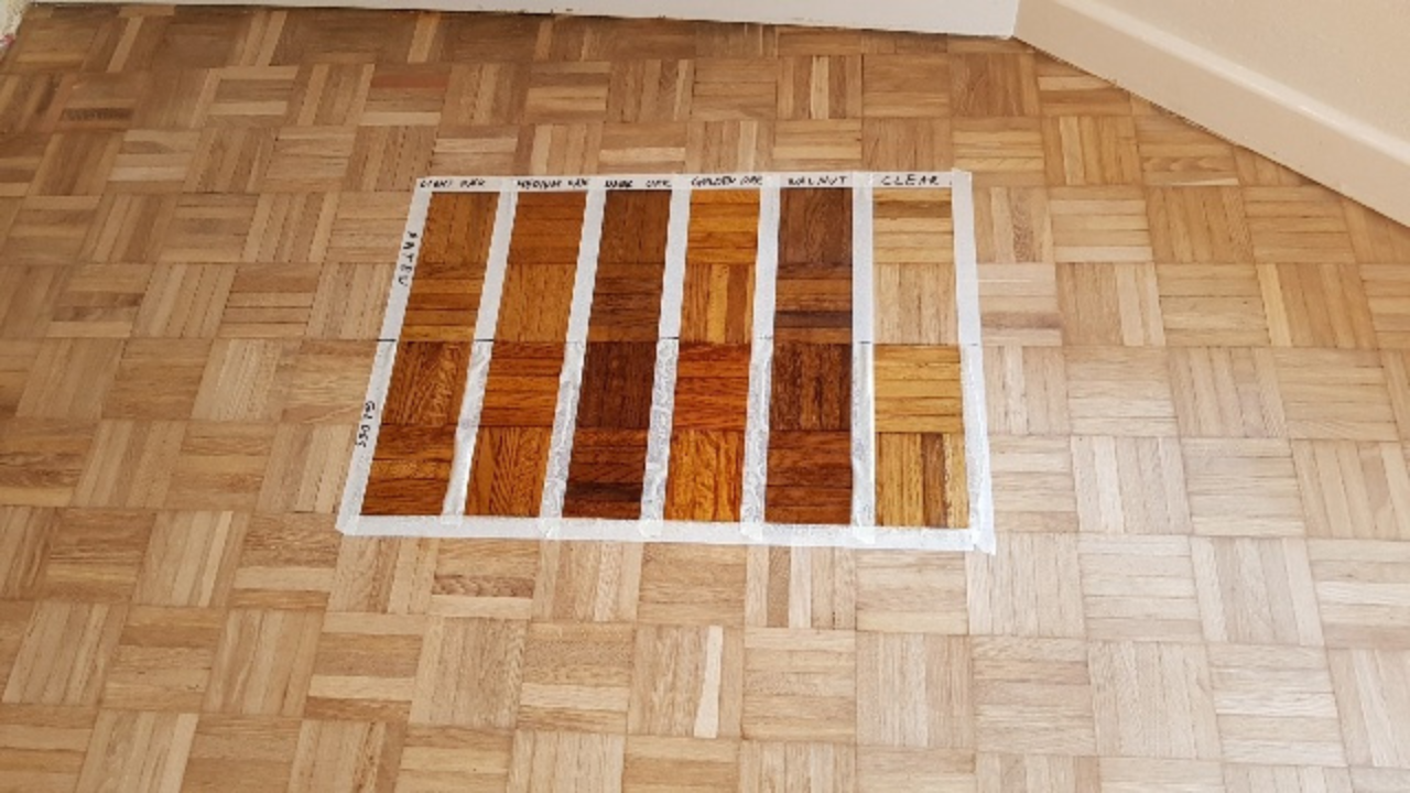 Wood Floor Sanding in Rainham on an oak mosaic parquet wood floor, showing stain sample panels tested in the centre of the room.