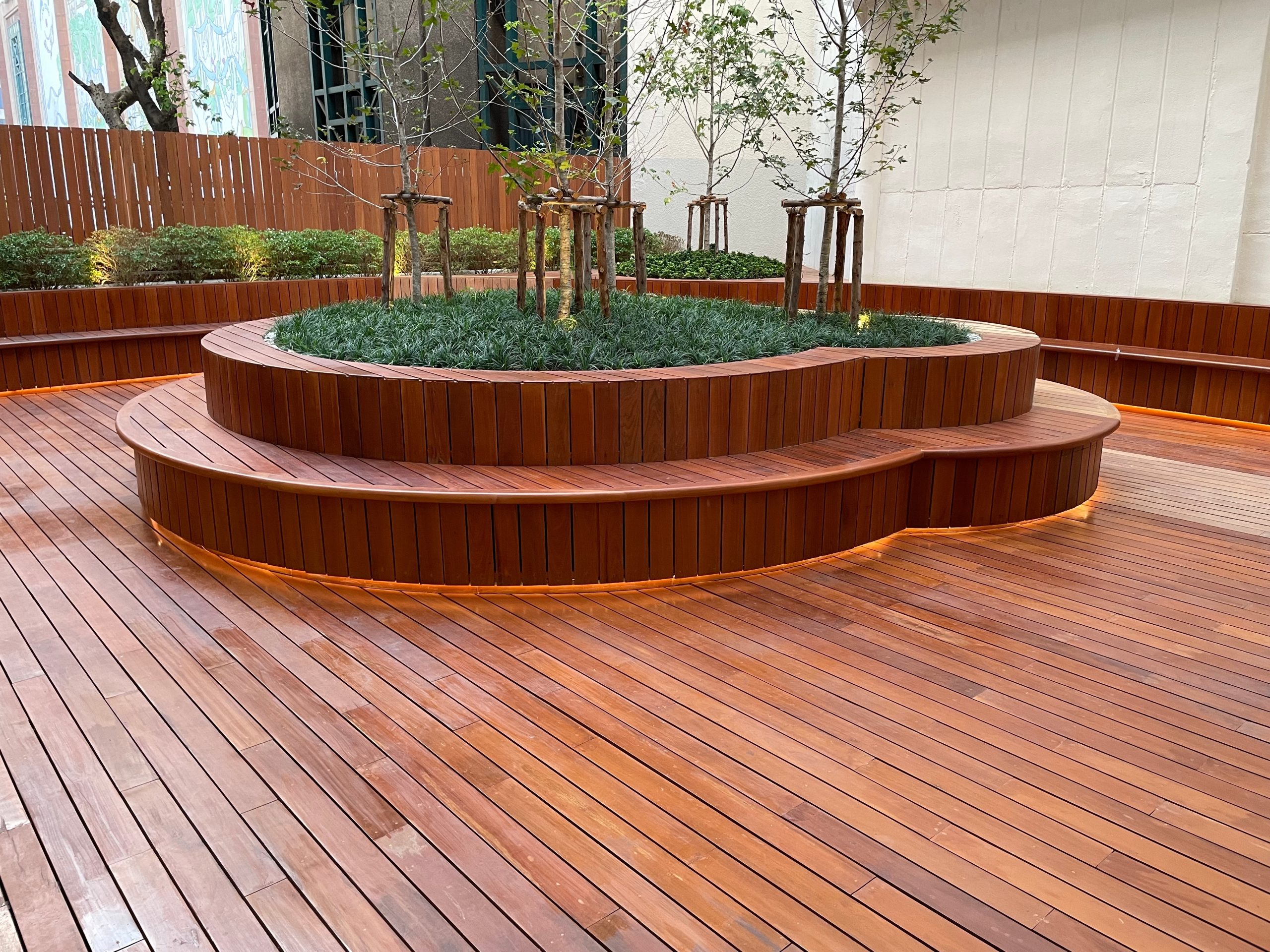Deck Sanding in Rainham – beautifully restored hardwood courtyard deck flooring with curved raised planters and seating.