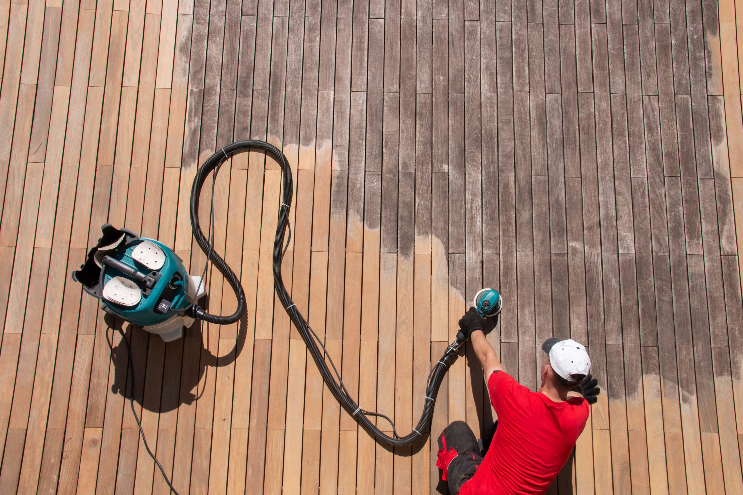 Deck Sanding in Rainham – hardwood timber deck floor being professionally sanded, showing the contrast between grey weathered boards and freshly restored timber.