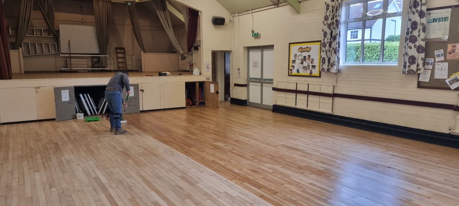 Commercial Floor Sanding in Rainham – maple strip hardwood community hall floor restoration with finishing work in progress for a tough, long-lasting commercial surface.